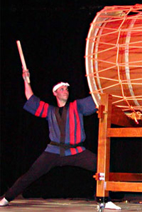 Marco Lienhard performs on stage on a large taiko in Switzerland
