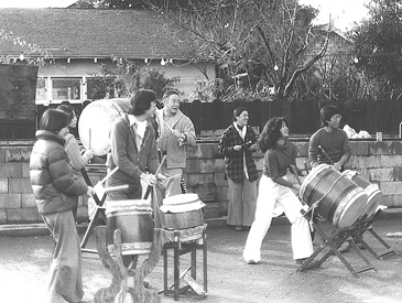 Members of San Jose Taiko drumming on the sidewalk