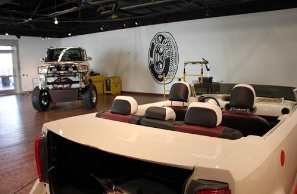 Painted monster truck and Scion video game car with Zen Garage logo on wall