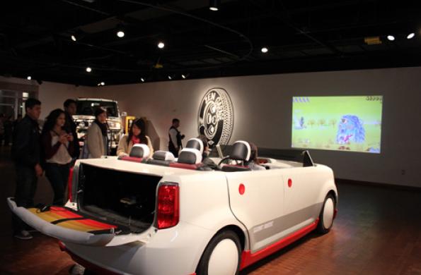 car with video game controller and projection of video game