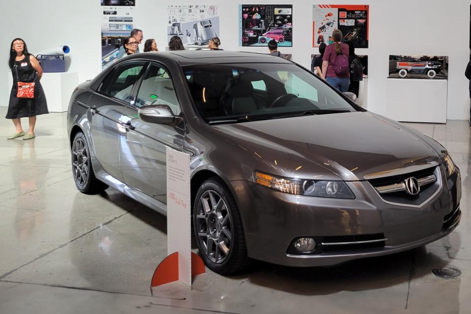 people in gallery looking at car related exhibition