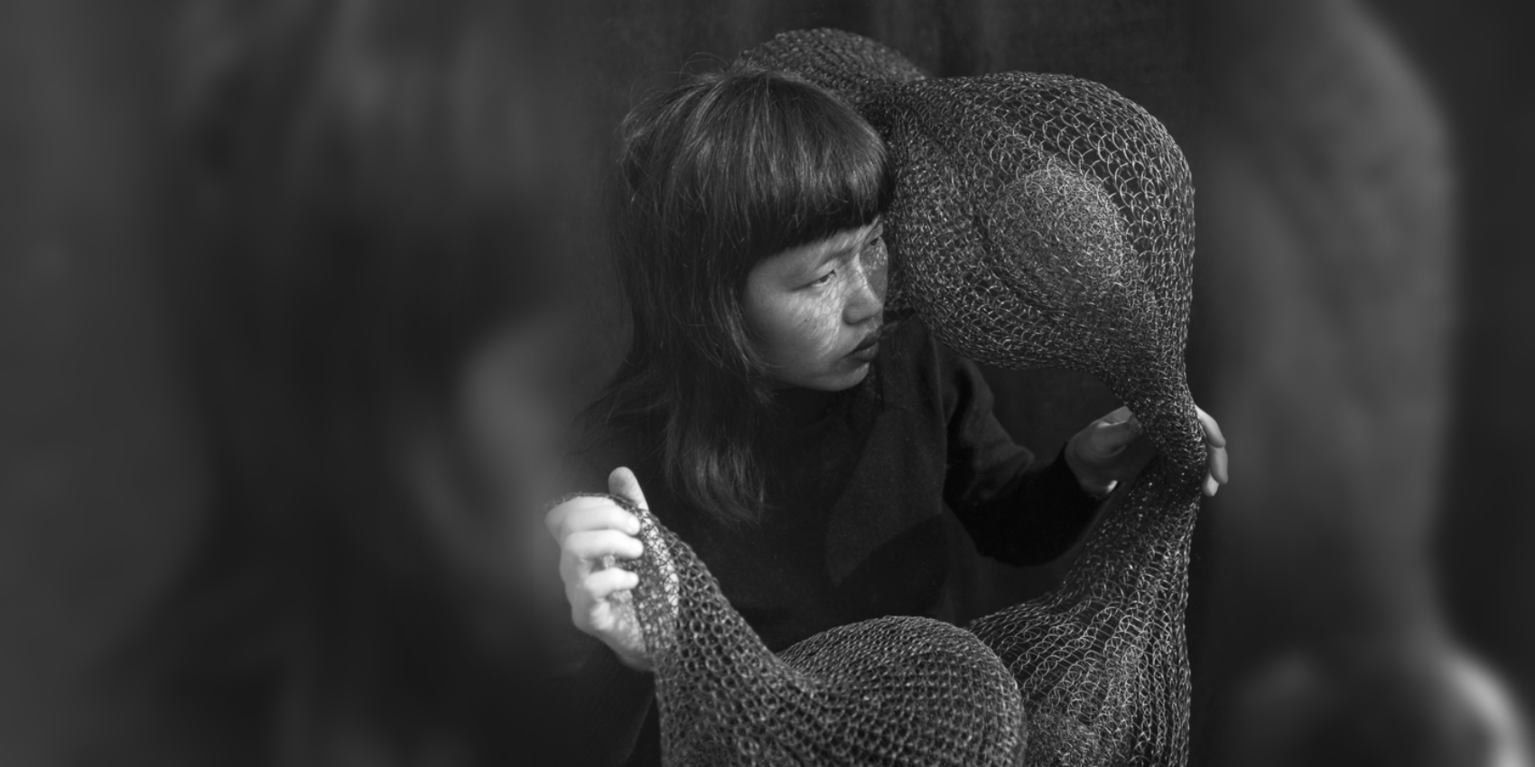Ruth Asawa holding "A For Within Form" sculpture