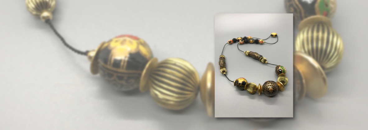 A beaded necklace made of wooden beads covered in "washi" (traditional Japanese paper).