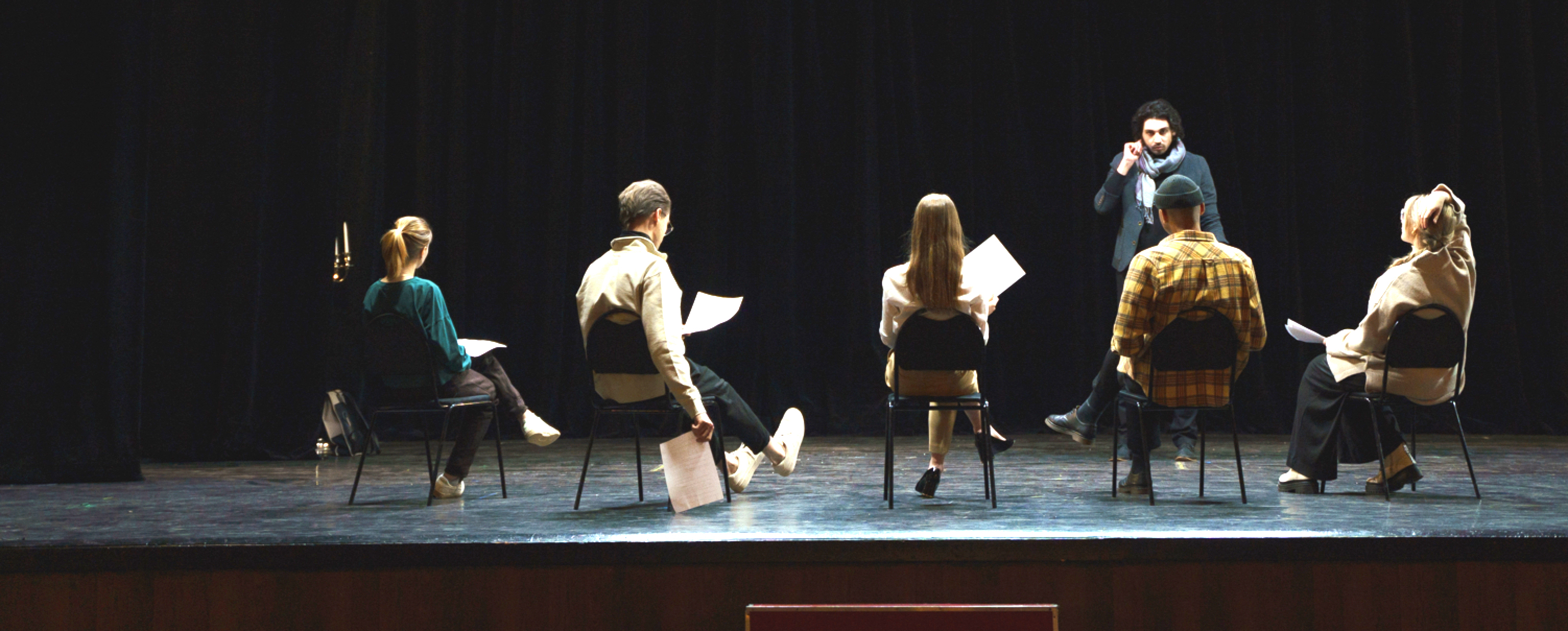 a group of people sitting in chairs on stage