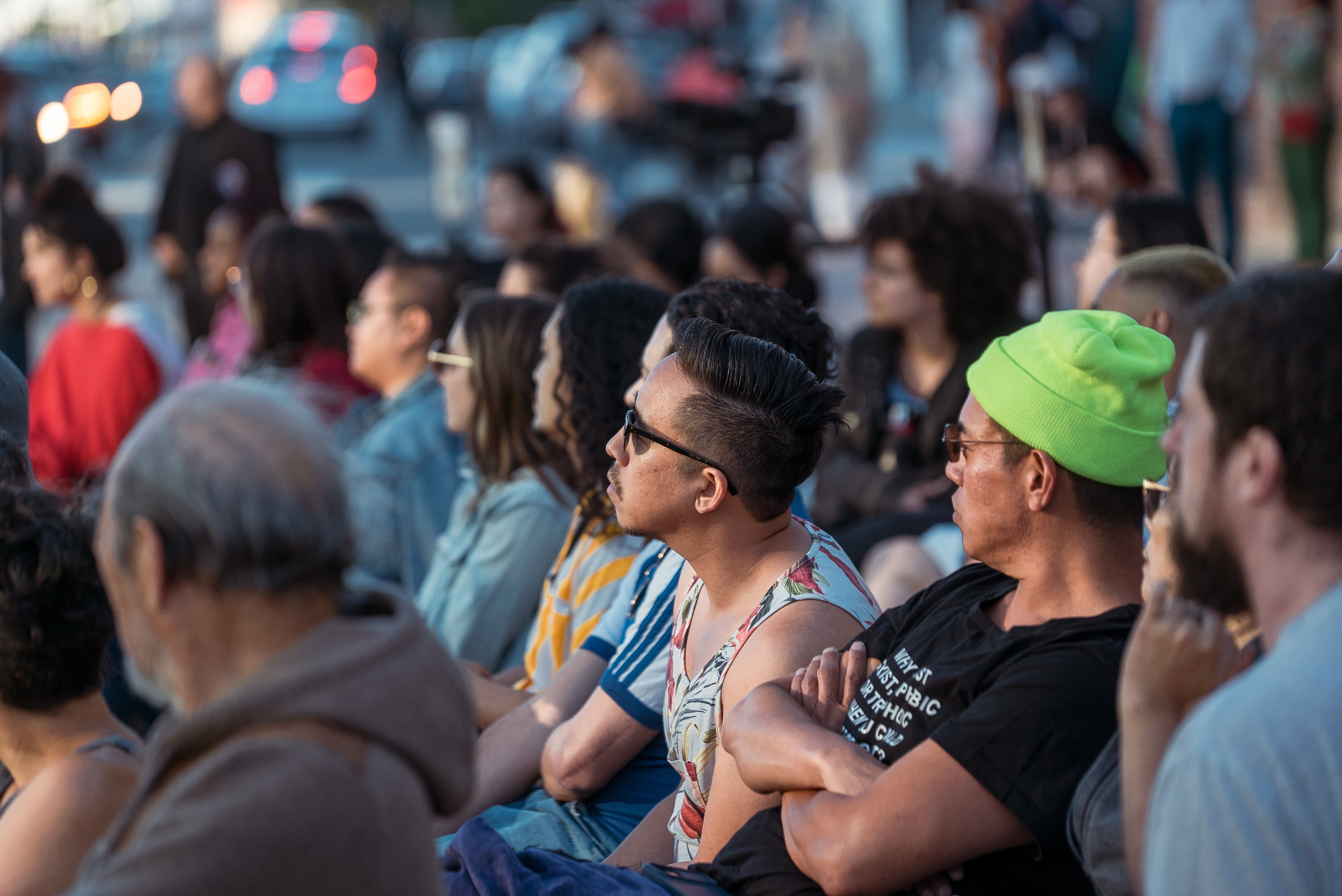 seated crowd watching program outside in plaza
