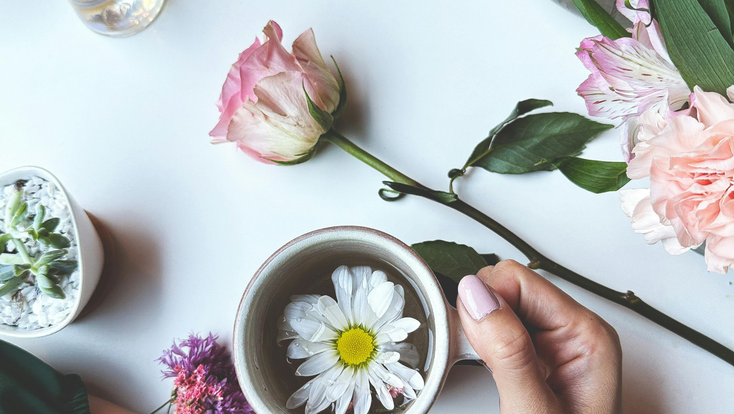 photo of flowers on table and in cup