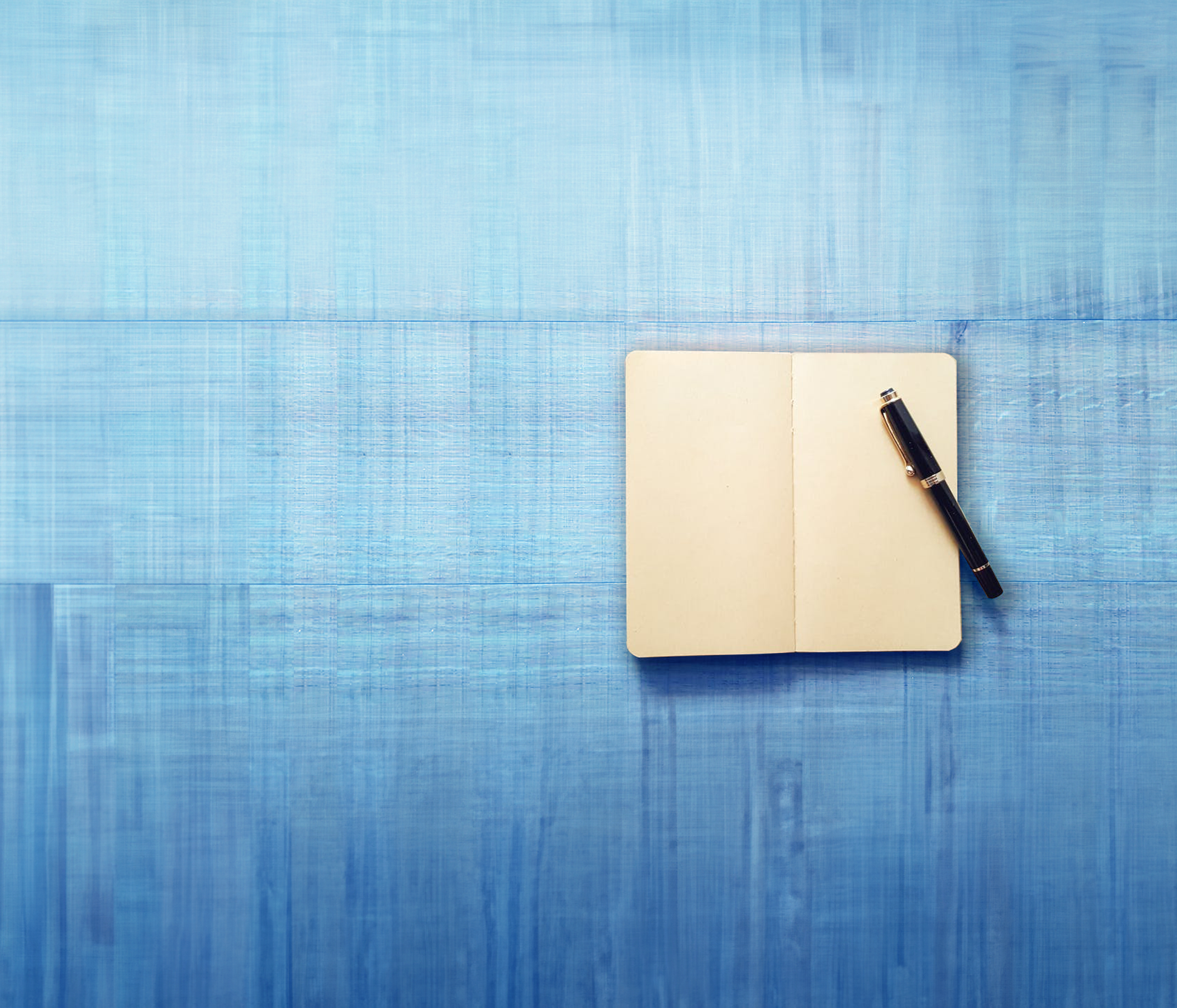 book open to blank pages with pen