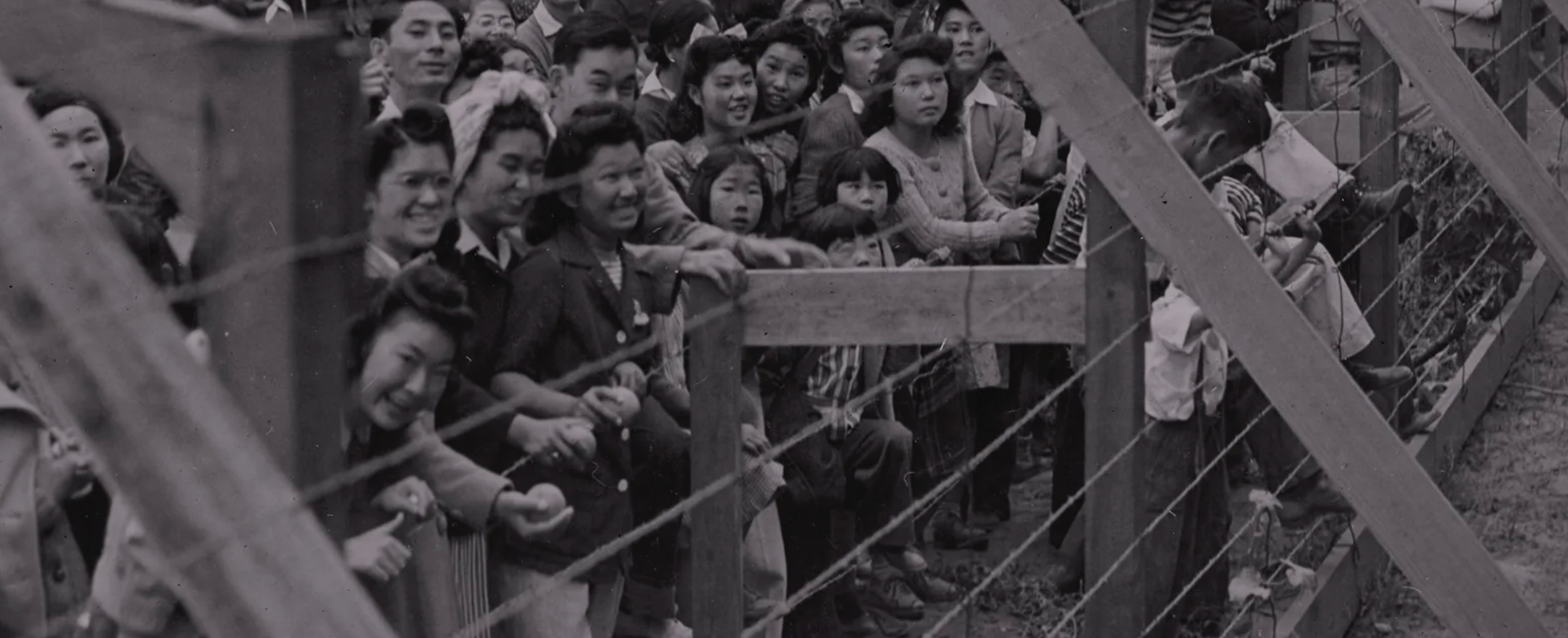 incarcerees behind barbed wire in camps