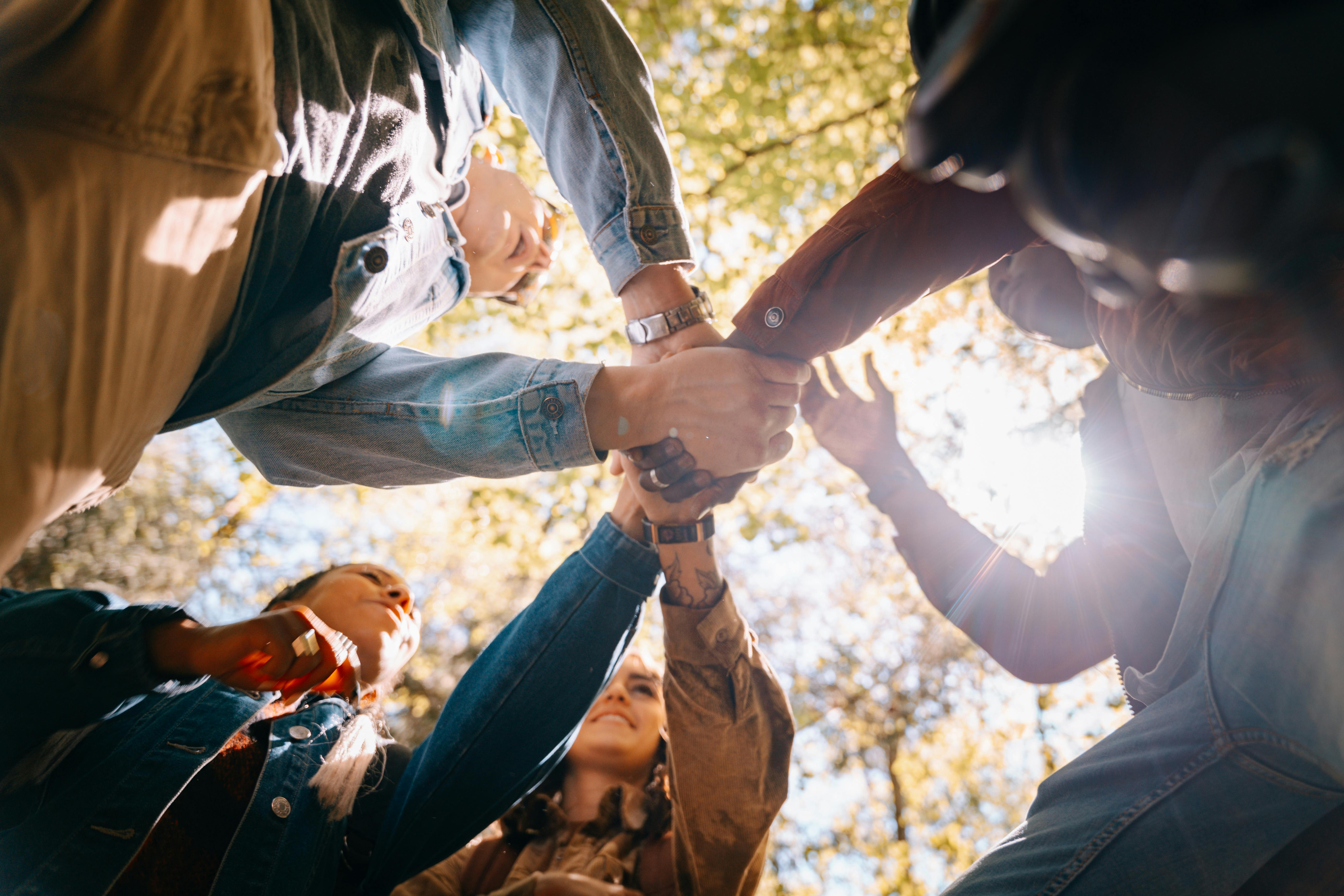 various people joining hands in circle