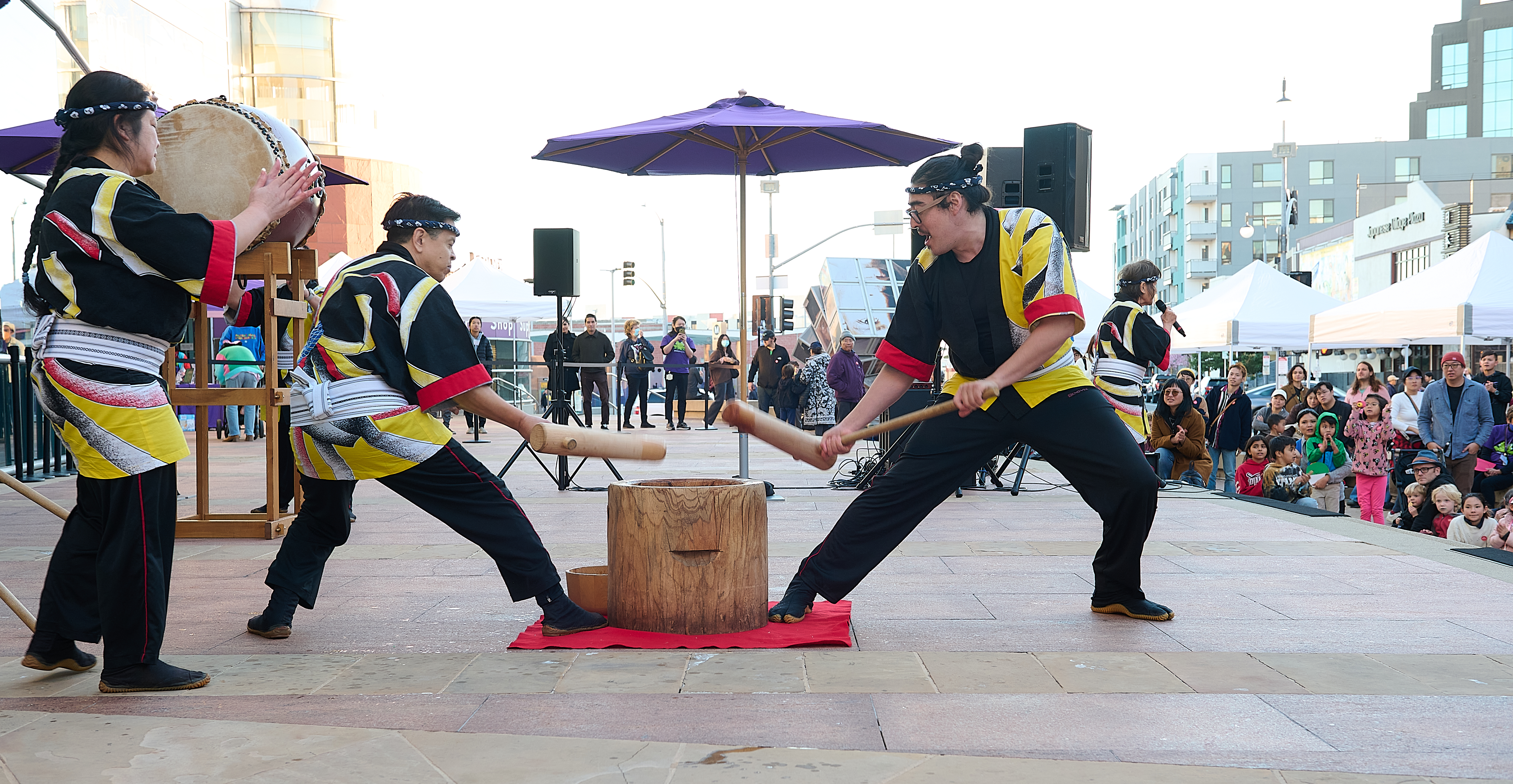 Taiko group pounding mochi at family festival in front of crowd