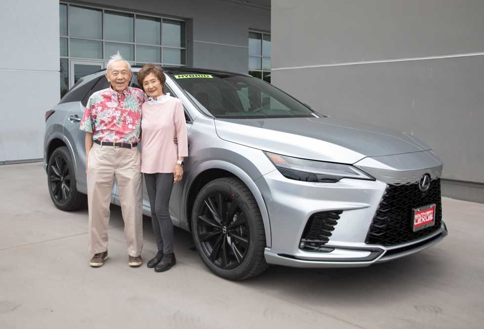 winners of the lexus pose in front of their car