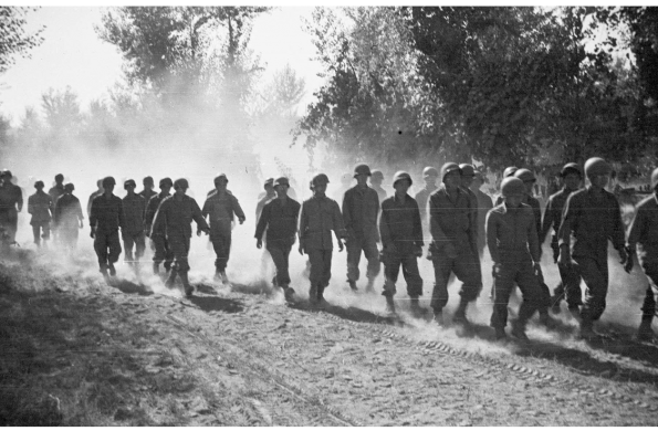 Soldiers of the 522nd Field Artillery Battalion marching along a dirt road in Naples, Italy, May 1944.
