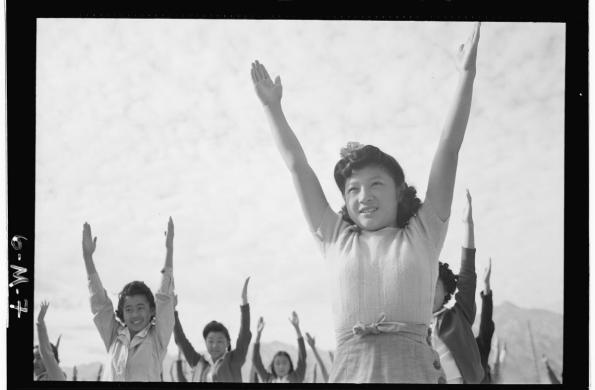 Women with arms in the air during calisthenics class at Manzanar concentration camp