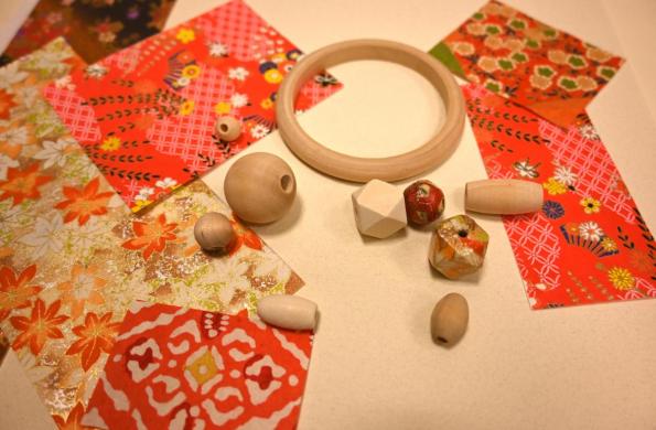 Wooden beads photographed next to Japanese paper.
