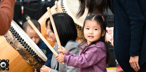 Little girl playing the taiko drums
