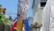 A colorful paper windsock blows in the wind in front of a blue sky