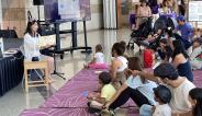 woman reading book to children
