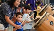 little boys playing taiko with mom help