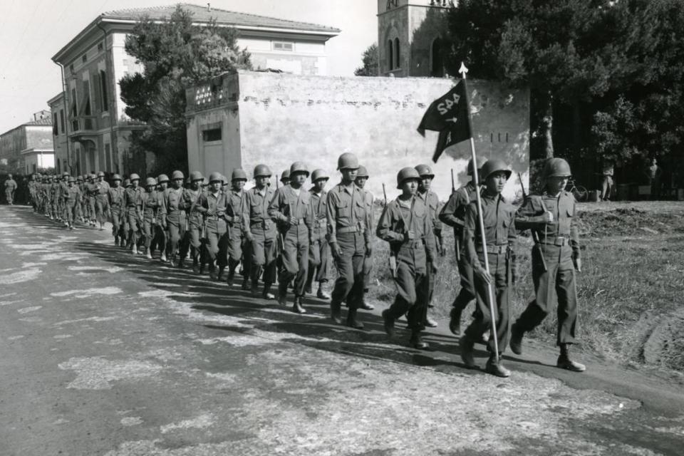 Company H, 442nd Regimental Combat Team, marches through a recently liberated town in Italy.
