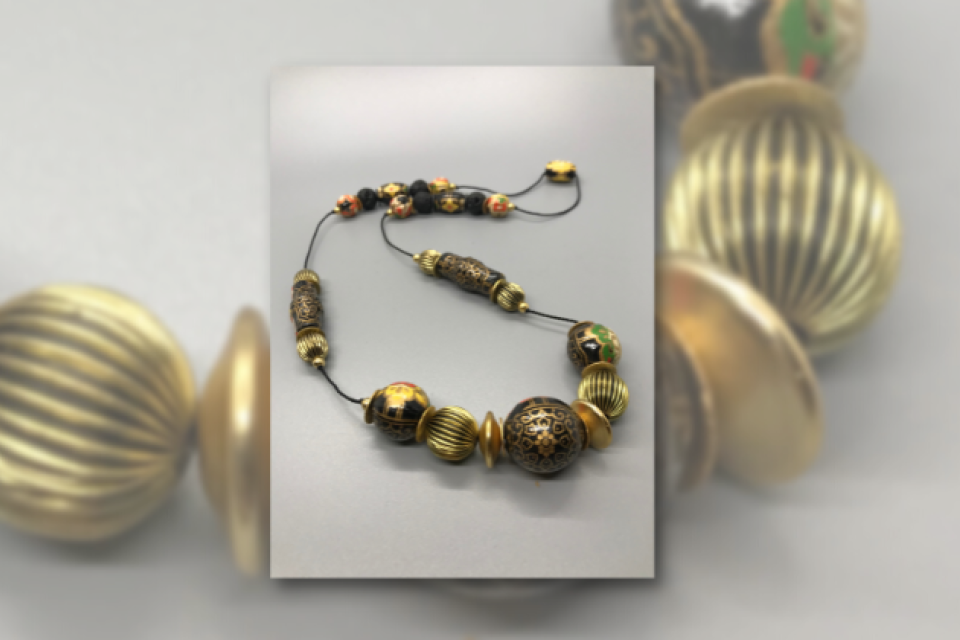 A beaded necklace made of wooden beads covered in "washi" (traditional Japanese paper).