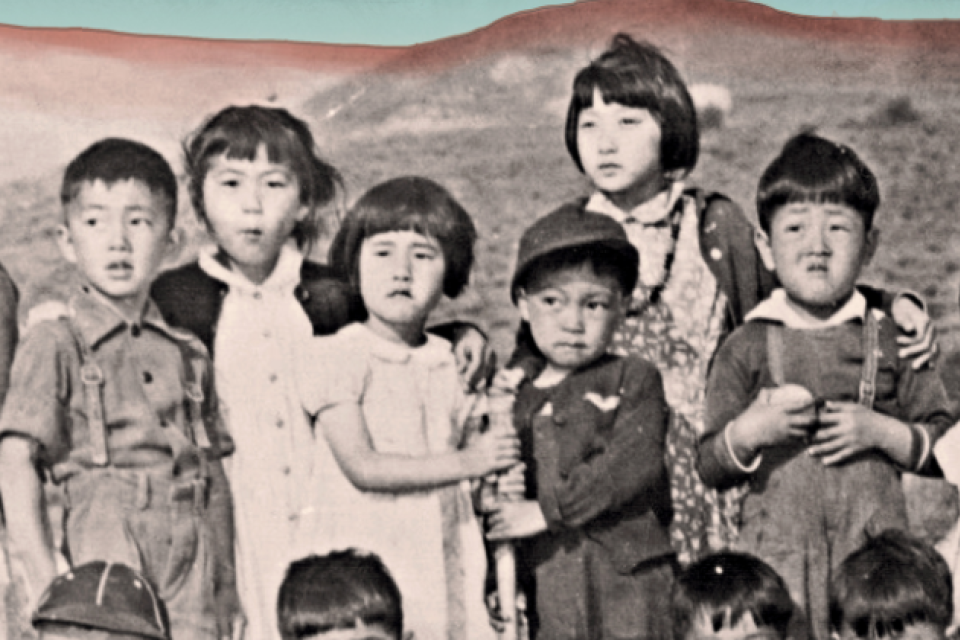 A group of Japanese American children in black and white, against a desert background with a blue sky.