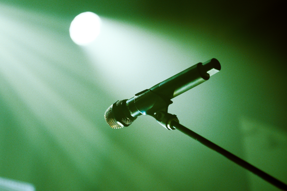 microphone on stage with spotlights on green background 