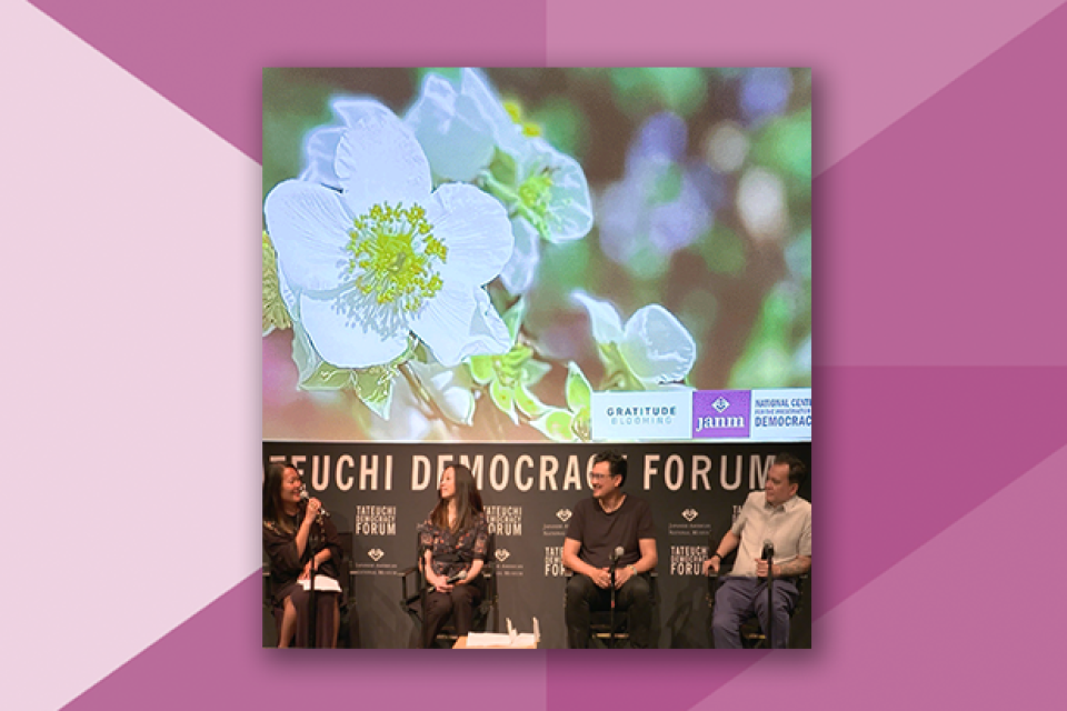 4 people sitting down for a discussion panel in front of a screen with a flower . On a pink geometric background