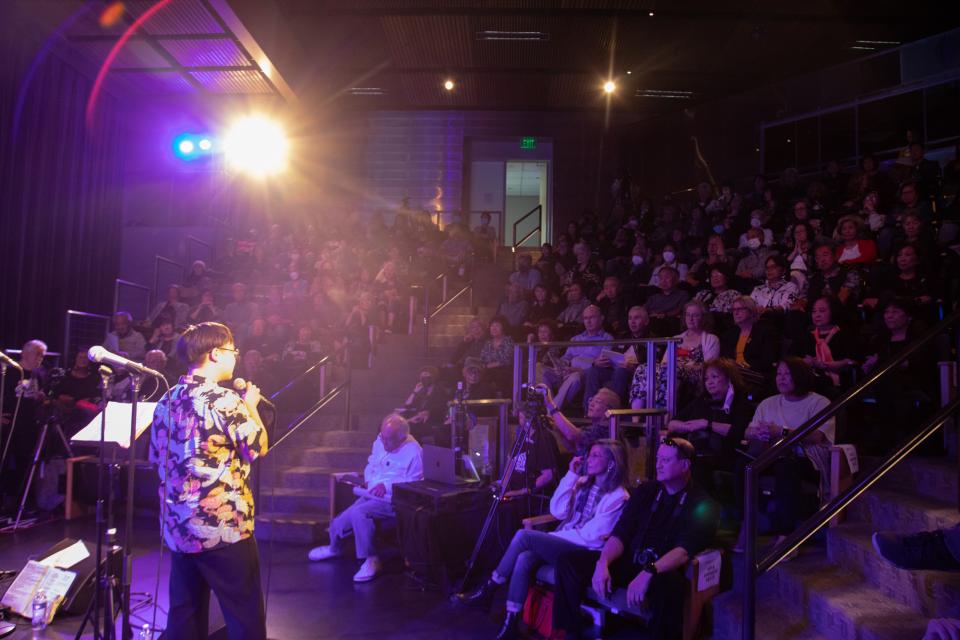 host talking to the crowd in tateuchi forum auditorium