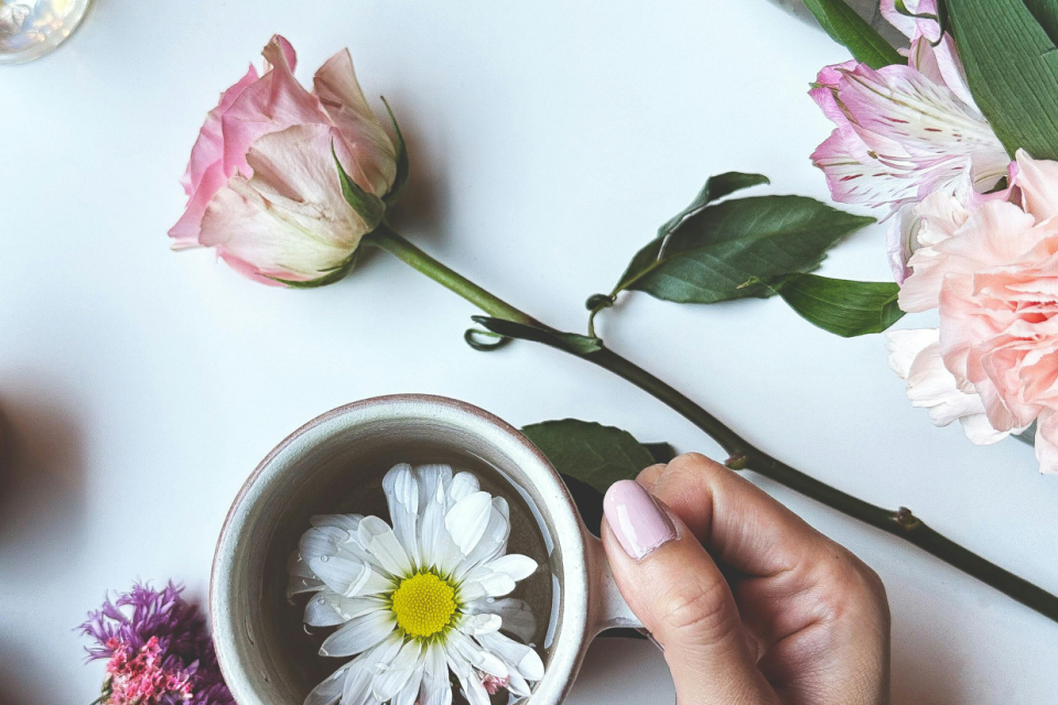 photo of flowers on table and in cup