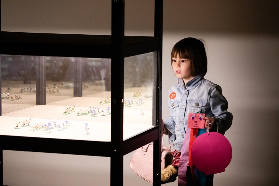 A little girl looking at art display in a museum