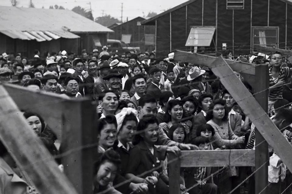 incarcerees behind barbed wire in camps