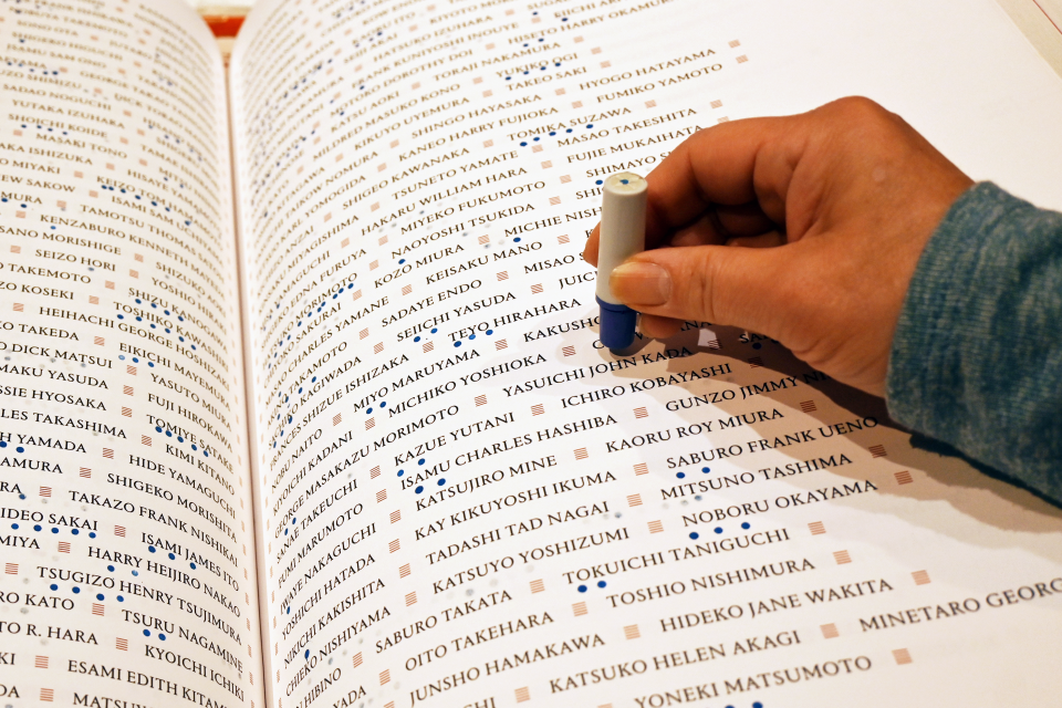 Hand stamping the Ireicho book of names