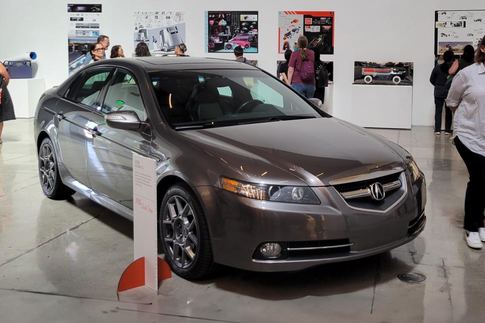 people looking at car in car exhibition gallery