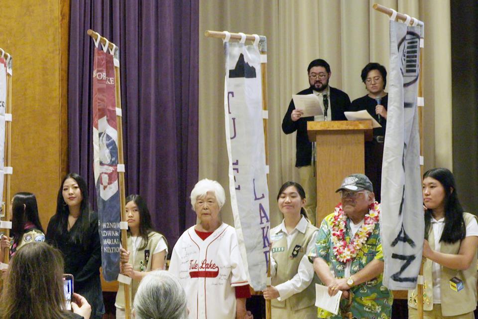 Day Of Remembrance program, people holding the flags of the camps