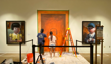 artist painting mural on wall of gallery