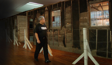 man looking at barrack in museum